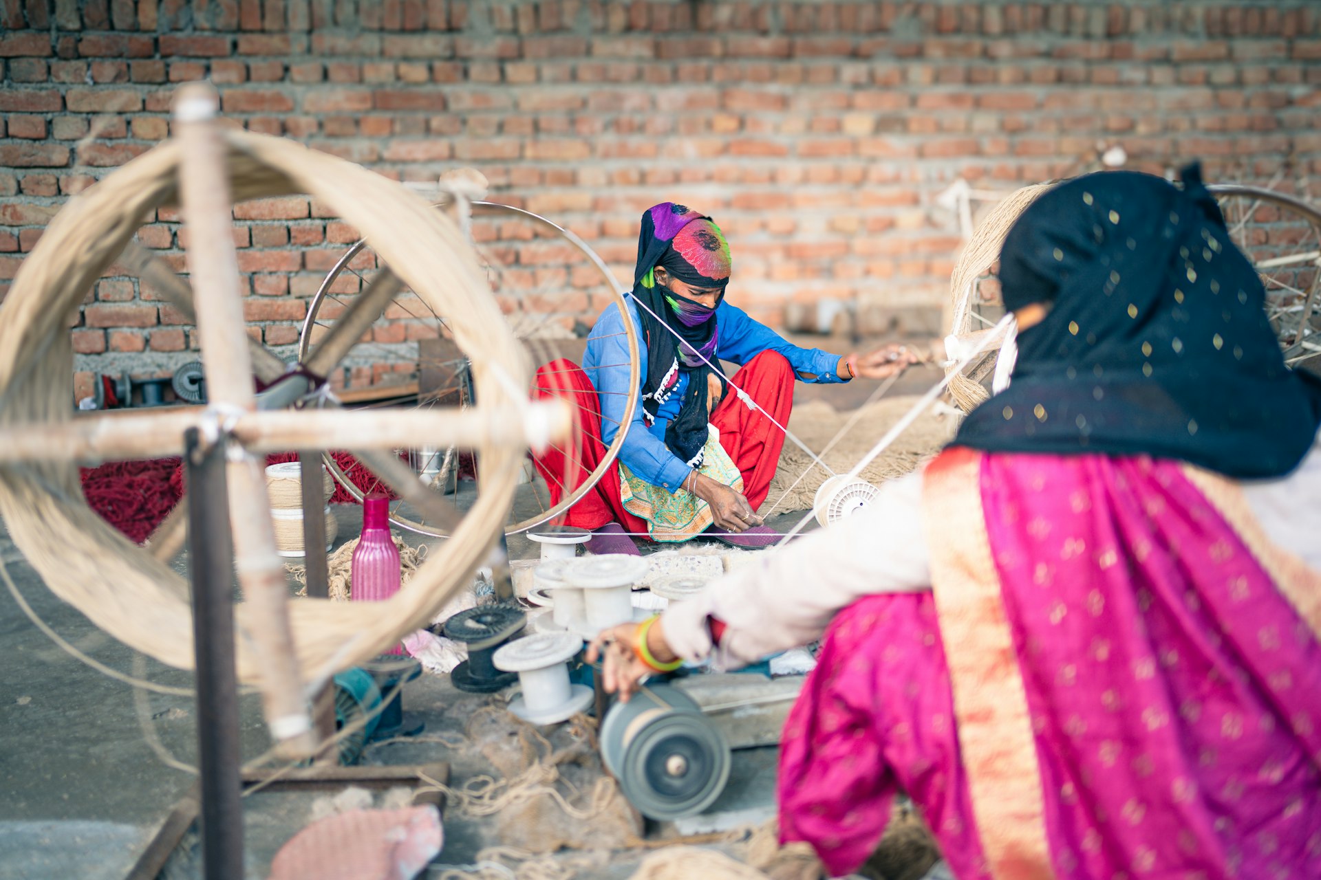 A woman sitting in front of a spinning wheel